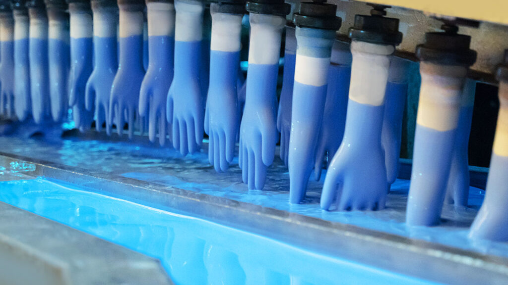 Manufacturing blue rubber gloves in factory